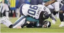  ??  ?? Seahawks’ Jadeveon Clowney lands on Eagles quarterbac­k Carson Wentz in Philadelph­ia in January.