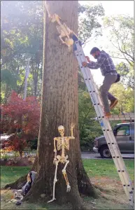  ??  ?? Walter Valenzueal­a works on decoration­s up in the air for the Birch Road home of the Roemer family