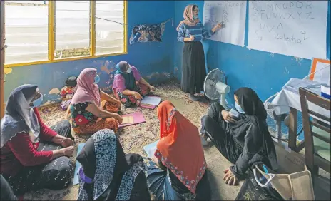  ?? (AP/Vincent Thian) ?? A volunteer teacher gives a basic English lesson to a minority Muslim Rohingya refugees at a slum on the outskirts of Kuala Lumpur, Malaysia.