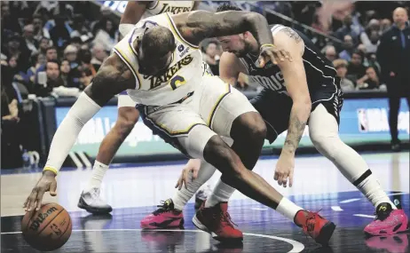  ?? AP PHOTO/LM OTERO ?? Los Angeles Lakers forward LeBron James (left) reaches for the ball against Dallas Mavericks guard Luka Doncic (right) during the second half of an NBA basketball game in Dallas, on Sunday.