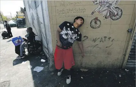  ?? Luis Sinco Los Angeles Times ?? A MAN BELIEVED to be feeling the effects of a synthetic cannabinoi­d called “spice” leans against a wall at 5th and San Pedro streets in downtown L.A.’s skid row. Fourteen people were sent to the hospital Friday, their symptoms thought to be linked to the drug.