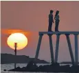  ?? ?? Sunrise over Sean Henry’s Couple artwork at Newbiggin-by-the-Sea, Northumber­land