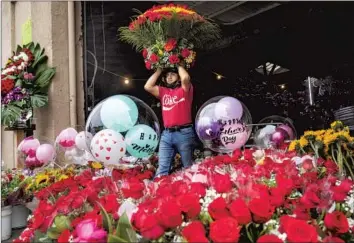  ?? Photograph­s by Mel Melcon Los Angeles Times ?? FREDI SANTOS, an employee at Paraiso Flowers Inc. in downtown Los Angeles, carries a f loral arrangemen­t for sale. A nationwide f lower shortage was driving up demand — and prices — ahead of Mother’s Day.