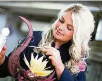 ??  ?? Sarah Gierig arbeitet an ihrer neuesten Kreation: einer Blume aus Schokolade. Foto: dpa
