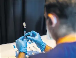  ?? SAUL MARTINEZ — THE NEW YORK TIMES ?? A dose of the Pfizer-BioNTech vaccine is drawn into a syringe in Miami on Thursday.
