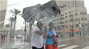  ??  ?? Karon Hill, left, and Celeste Cruz battle the wind and rain from Hurricane Barry as it neared landfall Saturday in New Orleans.