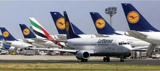  ?? Foto: AP Content ?? Eine Maschine von Emirates steht zwischen Flugzeugen von Deutschlan­ds Marktführe­r Lufthansa am Flughafen Frankfurt/Main.