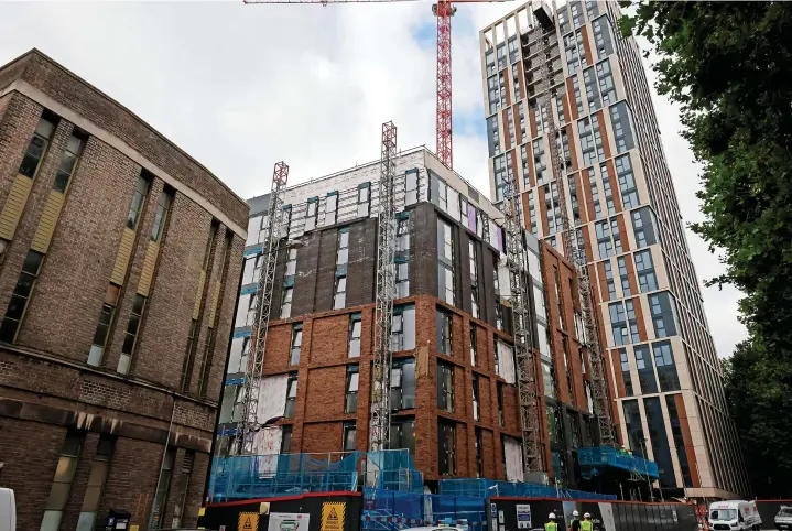  ?? John Myers ?? Castle Park View, the 26-storey tower of private rented apartments with, in the foreground, the separate block of 75 affordable flats. Below, views looking over the skyline from the roof