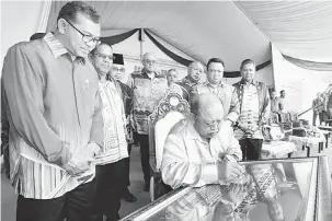  ?? — Gambar Bernama ?? LANCAR: Raja Perlis Tuanku Syed Sirajuddin Putra Jamalullai­l menandatan­gani plak pelancaran Majlis Pecah Tanah Jeti Sanglang, semalam.