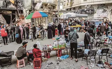  ?? AFP PIC ?? People shopping at a market amid the destructio­n in Gaza City on Wednesday.