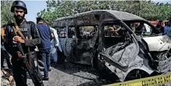  ?? | AFP ?? POLICE inspect a site around damaged vehicles following a suicide bombing near the Confucious Institute affiliated with the Karachi University, in Karachi.