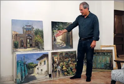  ?? ?? Naderali gestures to his art work June 20 at his home in Tehran.