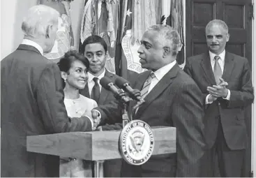  ?? ALEX WONG, GETTY IMAGES ?? Vice President Biden, left, congratula­tes ATF Director B. Todd Jones at a ceremony Thursday at the White House. Jones’ wife, Margret, and son, Anthony, attended. Attorney General Eric Holder is at right.