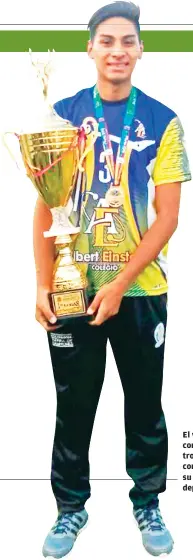  ??  ?? El voleibolis­ta con uno de los trofeos que conquistó en su carrera deportiva.