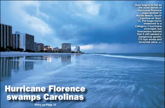  ?? AFP ?? Rain begins to fall as the outer bands of Hurricane Florence make landfall in Myrtle Beach, South Carolina on Sept. 13. The huge storm weakened to a Category 2 hurricane overnight, but forecaster­s warned that it still packed a dangerous punch, 175 kph winds and torrential rains.