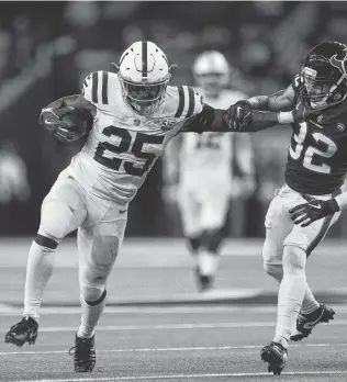  ?? Godofredo A. Vasquez / Staff photograph­er ?? Colts running back Marlon Mack (25) stiff-arms Texans free safety Tyrann Mathieu (32) in the fourth quarter. Mack finished with 148 yards on 24 carries and scored on a 2-yard run.