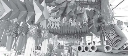  ?? PNA Photo ?? A hard-working grandmothe­r makes more "parol" to meet orders and earn extra income for the coming Christmas season at the Plaza Quezon in Las Pinas City.