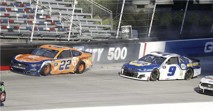  ?? AP ?? KNOCKOUT: Joey Logano (22) and Chase Elliott (9) limp through turn four after colliding with three laps remaining in a NASCAR Cup Series race. Racing 1-2, their cars made contact in the fourth turn and drifted into the wall, allowing Brad Keselowski to come from third place for the win.