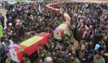  ?? HAWAR NEWS AGENCY VIA AP ?? This photo provided by Hawar News Agency, a Kurdish-run news agency, which has been authentica­ted based on its contents and other AP reporting, shows fighters from the predominan­tly-Kurdish Syrian Democratic Forces carrying the coffins of their...