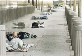  ?? Francine Orr Los Angeles Times ?? LEWIS PAYNE, 55, settles in for the night on the sidewalk on Aliso Street not far from the new trailers opening next month near downtown’s historic El Pueblo.