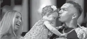  ?? ALBERT CESARE/THE ENQUIRER ?? While waiting to be drafted, Cincinnati quarterbac­k Desmond Ridder kisses one-year-old daughter Leighton. Ridder was eventually selected in the third round by the Atlanta Falcons.