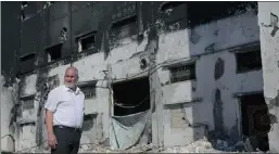  ?? Picture: AP ?? Mohammed al-Telbani, owner of Al Awda snack food factory, stands in front of his burnt factory in Deir el-Balah, central Gaza Strip.