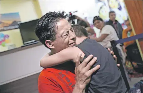  ?? John Moore ?? A FATHER embraces his son for the first time in months on Tuesday in Guatemala City. A group of nine children were flown from New York City and reunited with their families, months after U.S. border agents separated them and later deported their parents.