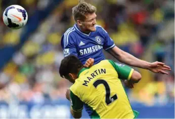  ?? BEN STANSALL/AFP/GETTY IMAGES ?? Norwich midfielder Russell Martin (2) vies for the ball with Chelsea’s Andre Schuerrle during Sunday’s match.