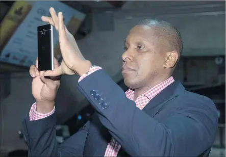  ?? — THE CANADIAN PRESS FILES ?? Toronto Raptors general manager Masai Ujiri takes photos of first round draft choice Delon Wright as he speaks to the media in Toronto on Friday.