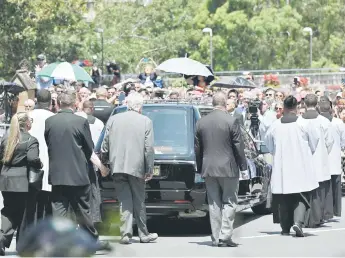  ?? — AFP photo ?? Mourners take part in the funeral procession of late Australian Catholic Cardinal George Pell outside the St. Mary’s Cathedral in Sydney.