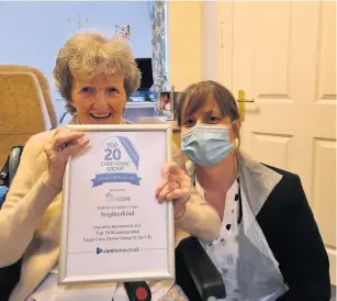  ??  ?? Ivybank House-resident Daphne and team member Lisa proudly holding the Top 20 award given to the home in the carehome.co.uk annual awards 2020