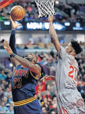  ?? [NAM Y. HUH/THE ASSOCIATED PRESS] ?? Cleveland Cavaliers forward LeBron James shoots against Chicago Bulls guard/forward Jimmy Butler during the first half Thursday in Chicago.