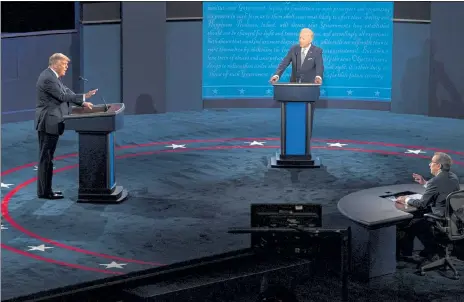  ?? RUTH FREMSON / NYTNS ?? President Donald Trump, left, and Democratic presidenti­al nominee Joe Biden speak at the first presidenti­al debate in Cleveland, Ohio, on Tuesday. Moderator Chris Wallace is at the far right.