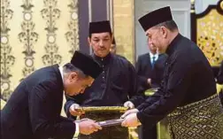  ??  ?? YANG di-Pertuan Agong menyerahka­n Surat Cara Pelantikan sebagai Menteri Pengangkut­an kepada Anthony Loke Siew Fook.