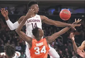  ?? Mary Altaffer / Associated Press ?? UConn forward Kassoum Yakwe, left, and Syracuse forward Bourama Sidibe vie for a rebound during the first half Thursday in the 2K Empire Classic at Madison Square Garden in New York.