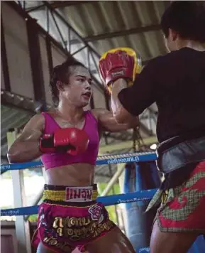  ?? AFP PIC ?? Muay Thai boxer Nong Rose (left) doing pad work with her brother during a recent training session.