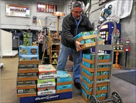  ?? PETE BANNAN – DIGITAL FIRST MEDIA ?? Exton Beverage owner Greg Ramirez moves cases of beer ahead of the law allowing beer distributo­rs to sell six packs starting today.