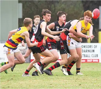  ?? ?? Longwarry’s Van Wilson (right) handballs to teammate Tarkyn Gilbert (left) while being tackled in the under 16s.