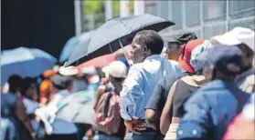  ??  ?? Social standing: Grant beneficiar­ies queuing to collect their money in Alexandra. Photo: Delwyn Verasamy