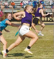  ?? Westside Eagle Observer/RANDY MOLL ?? Kaitlyn Caswell (11) carries the ball while Cayci Capps (10) tries to pull her flags, and Shelby Still (11) is in the background during Wednesday’s powderpuff football game in Gentry.
