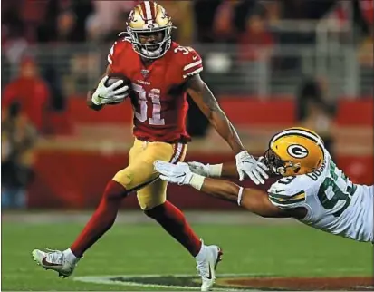  ?? ARIC CRABB — BAY AREA NEWS GROUP ?? San Francisco 49ers running back Raheem Mostert (31) runs past the tackle of Green Bay Packers defenseman Dean Lowry (93) in the fourth quarter of their NFC Championsh­ip game at Levi’s Stadium in Santa Clara on Sunday.