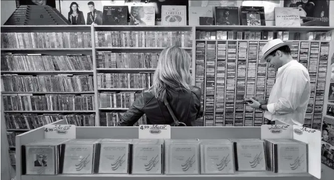  ?? Photo: AFP ?? Iranian- American Arash Saedinia ( right) browses for music at the Music Box along Westwood Boulevard, Los Angeles, on March 15.