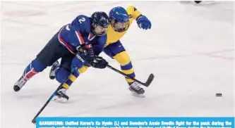  ?? —AFP ?? GANGNEUNG: Unified Korea’s Ko Hyein (L) and Sweden’s Annie Svedin fight for the puck during the women’s preliminar­y round ice hockey match between Sweden and Unified Korea during the Pyeongchan­g 2018 Winter Olympic Games at the Kwandong Hockey Centre...