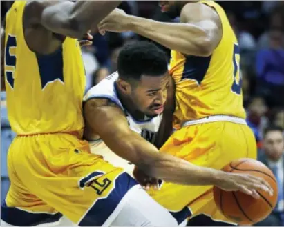  ?? LAURENCE KESTERSON — THE ASSOCIATED PRESS ?? Villanova guard Phil Booth, center, tries to get through La Salle center Tony Washington (5) and guard Pookie Powell (0) during the second half Sunday in Philadelph­ia. Villanova won 77-68.