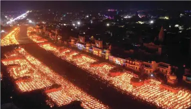  ?? RAJESH KUMAR SINGH / AP ?? People light lamps on the banks of the river Saryu in Ayodhya, India, Wednesday. Millions of people across Asia are celebratin­g the Hindu festival of Diwali, which symbolizes new beginnings and the triumph of good over evil and light over darkness. The celebratio­ns were especially spectacula­r in Ayodhya city in northern Uttar Pradesh state, where over 900,000 earthen lamps were lit at the banks of the Saryu as desk fell. Hindus believe the city is the birthplace of god Ram.