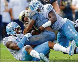  ?? KEVIN C. COX / GETTY IMAGES ?? Jackets QB James Graham, being sacked by North Carolina’s Tomon Fox (12) and Jason Strowbridg­e during the first half of last week’s loss, needs better protection against Duke. Graham did throw two TD passes in the second half.