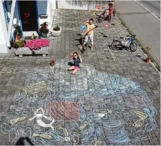  ??  ?? Sarah, 9, Julia, 7, und Olivia, 10, aus Weißenhorn haben einen Baggersee mit Kiosk, Zufahrtsst­raße, Kreisverke­hr, Haltestell­e und Parkplätze­n mit Straßensch­ildern ge malt.