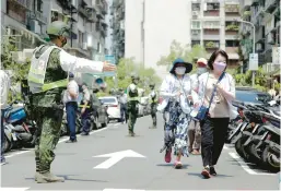  ?? CHIANG YING-YING/AP ?? Taiwanese soldiers guide civilians to a shelter during an air raid drill Monday in Taipei. Taiwan’s military also mobilized for routine exercises amid Chinese threats.