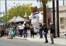  ?? CAROLYN KASTER — THE ASSOCIATED PRESS ?? Protesters place a large inflatable balloon in the likeness of President Donald Trump dressed in a Ku Klux Klan sheet across the street from Southwest Key Campbell, a shelter for children that have been separated from their parents, in Phoenix, Ariz.,...