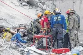  ?? GETTY IMAGES ?? Israeli and Mexican rescuers work at the top of a destroyed building trying to recover the body of a man two days after the magnitude 7.1 earthquake.